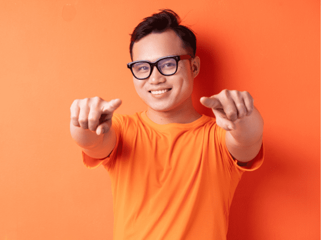 Man in an orange shirt points