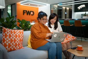 2 female colleagues talking about work in the office in the evening