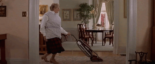 Woman is vacuuming a house while dancing