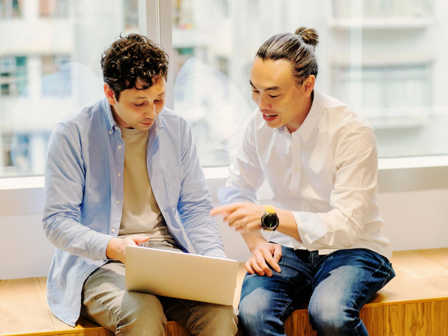 Employee points to his colleague's laptop