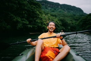 Man paddling kayak in mangrove river
