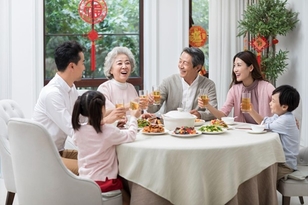 Happy multigenerational family enjoying Chinese New Year dinner together.